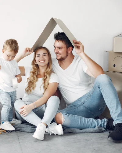 Familia realizando una mudanza y haciendo la forma de un tejado con cajas de carton